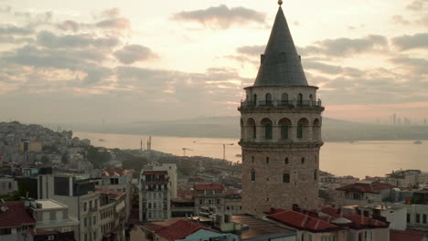 Beautiful-Galata-Tower-at-Sunrise-in-the-Heart-of-Istanbul-City-in-Yellow-light,-Aerial-View-from-above