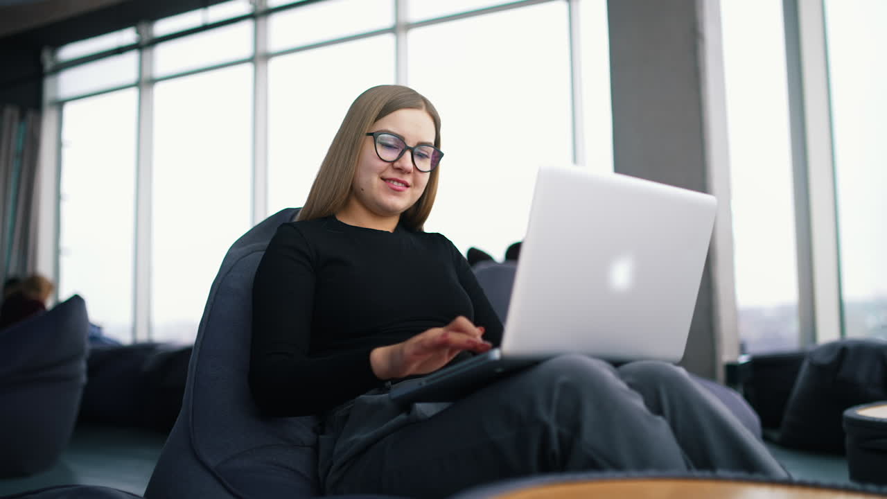 Young beautiful woman with glasses working on laptop.