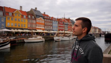 joven observando la atmósfera de nyhavn sitio icónico en copenhagen