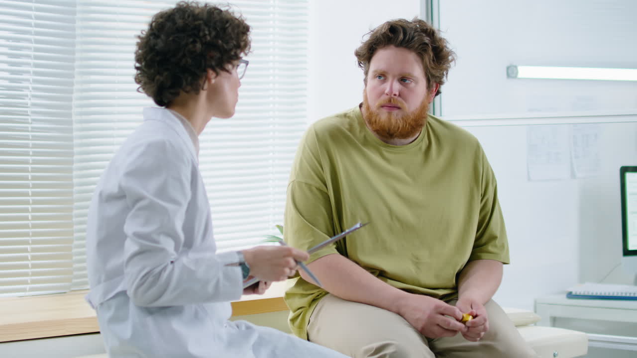 Female Doctor Consulting with Overweight Patient in Clinic
