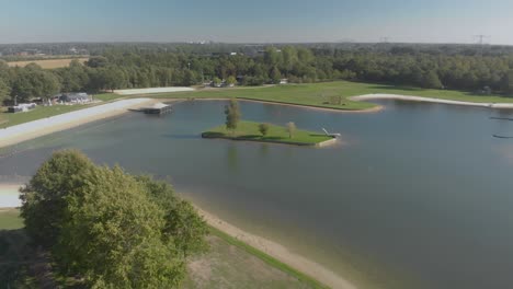 aerial view of an almost empty recreational swimming lake in the netherlands showing the islands, green fields and beaches surrounding it