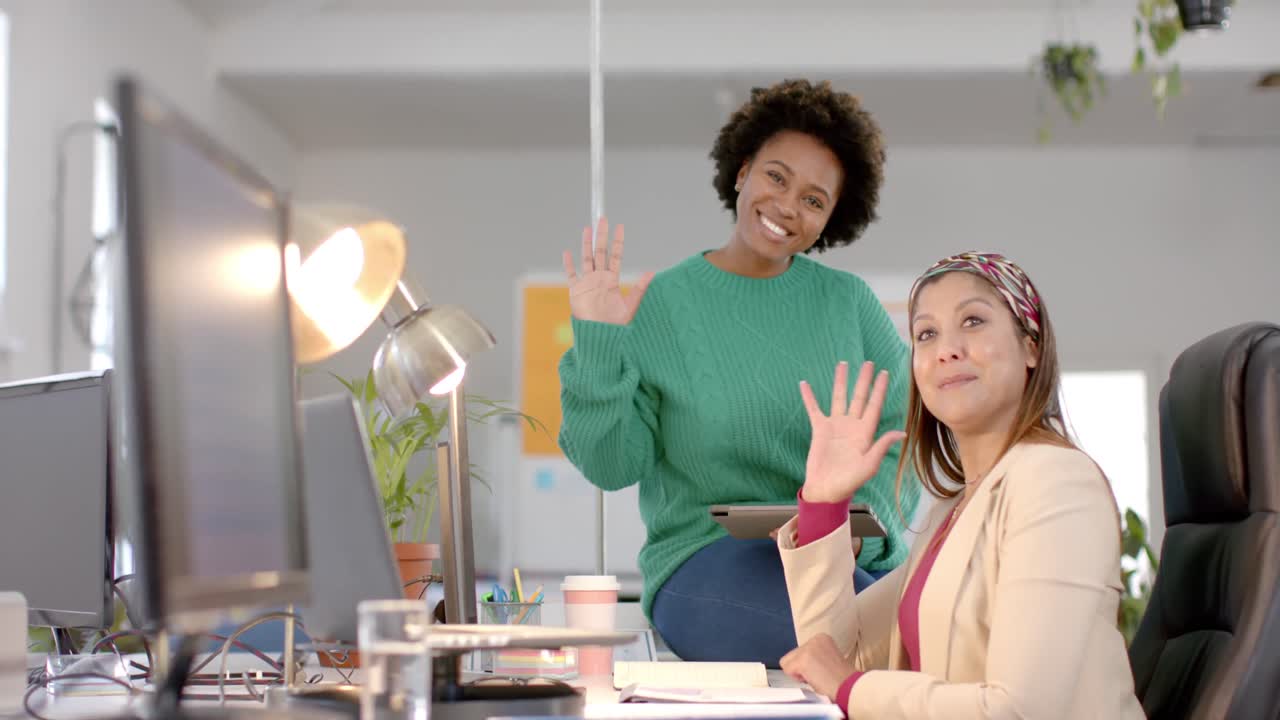 Retrato de diversas e felizes colegas de trabalho acenando em reunião casual de escritório, em câmera lenta