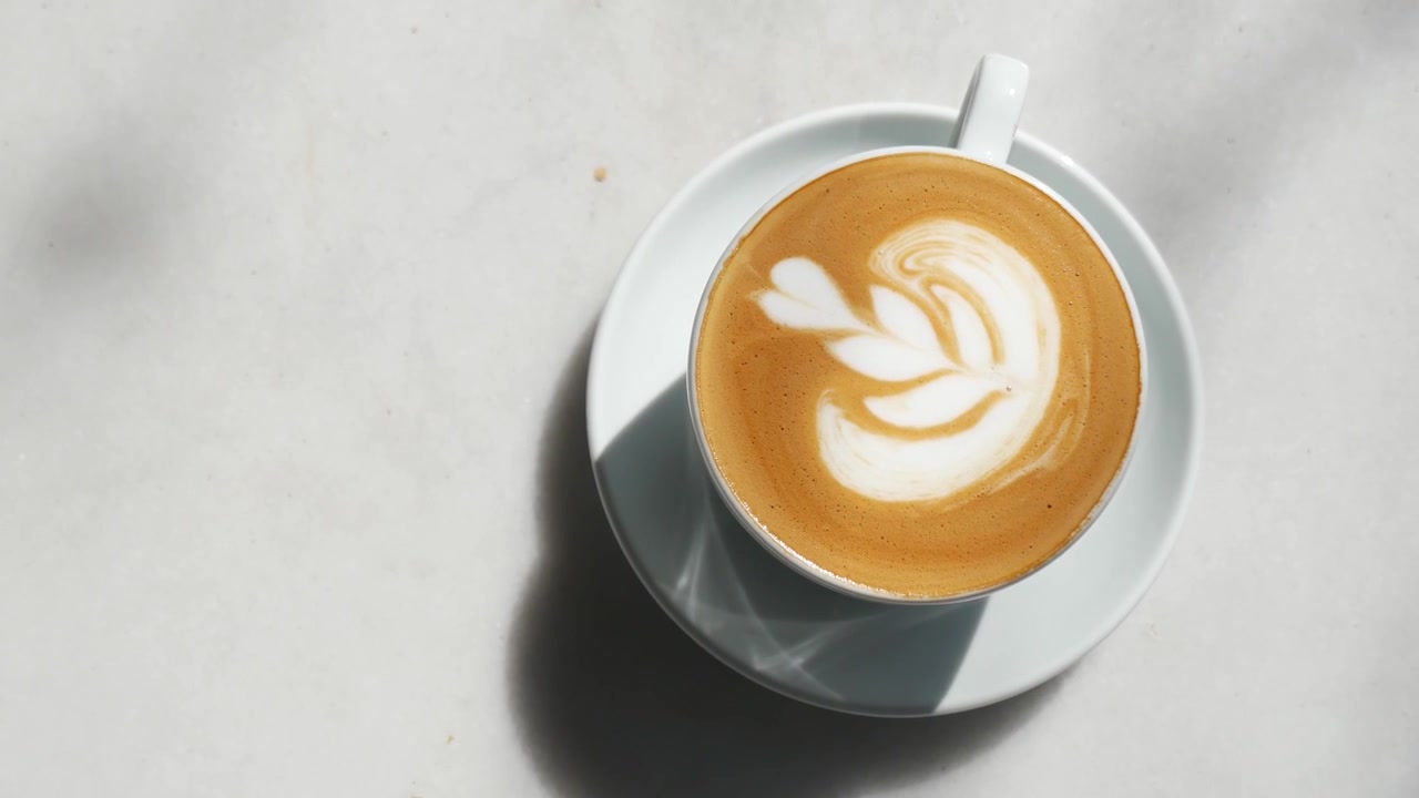 Vista dall'alto di un latte macchiato con una splendida latte art a foglia.