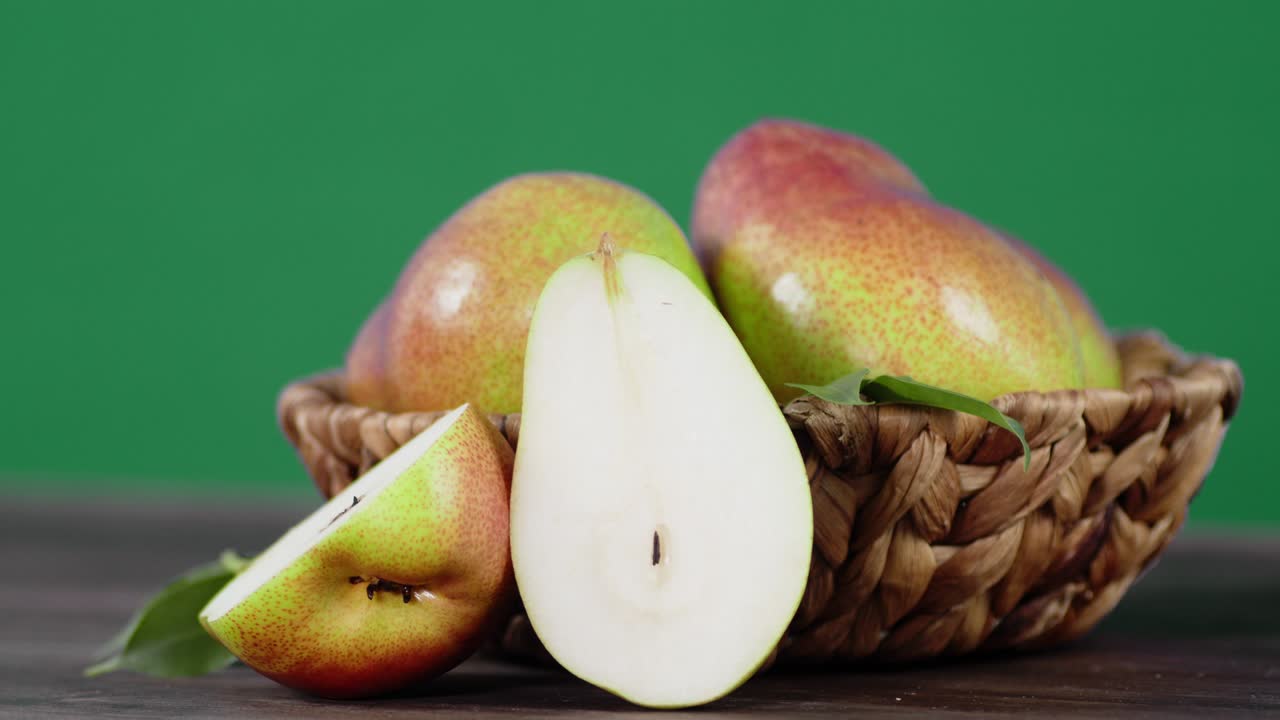 Half and whole ripe pear in the basket is slowly rotated.