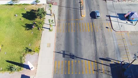 Cenit-view-of-a-drone-flying-forward-over-a-highway-near-the-coast-and-panning-up-showing-the-coast