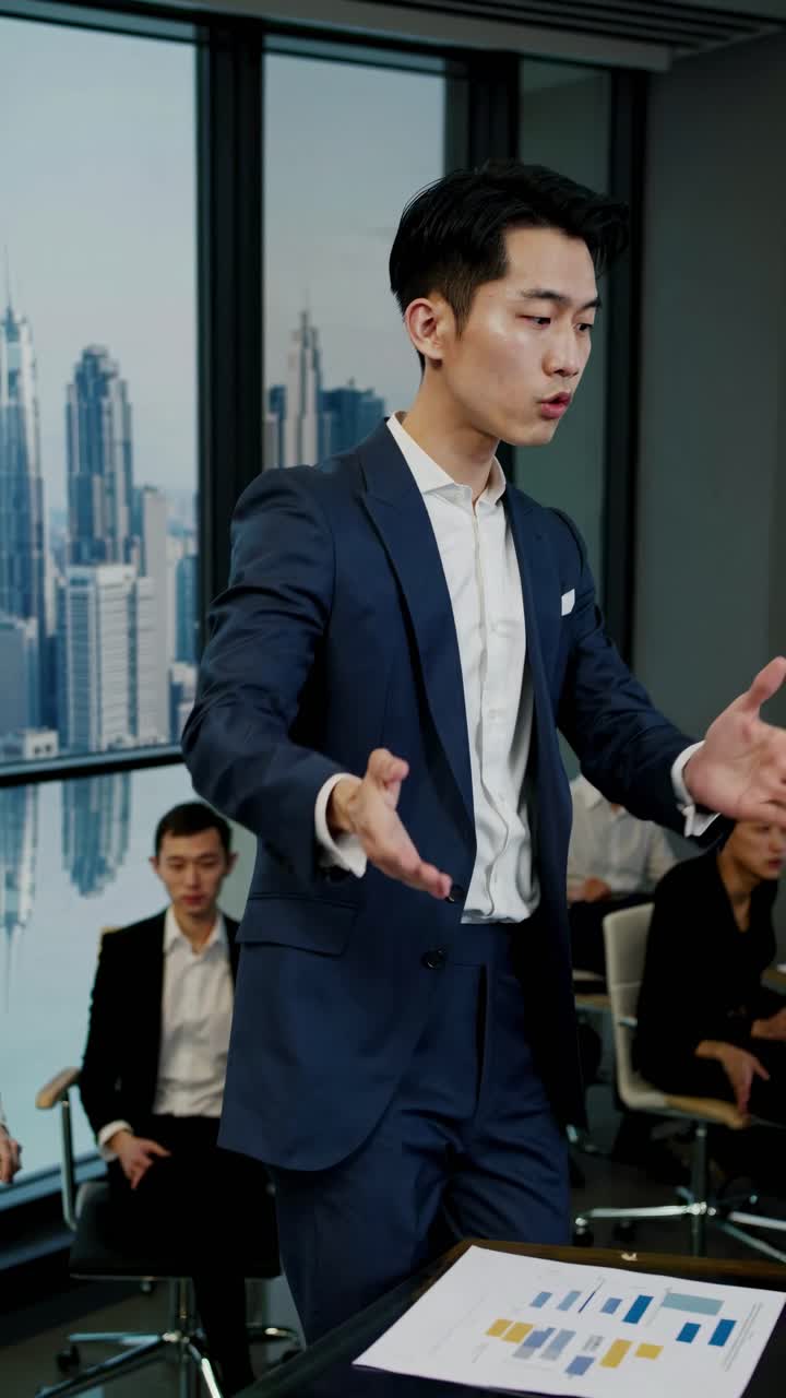 Video dinamis yang menampilkan suasana rapat bisnis, menampilkan pengambilan gambar dari sudut tengah seorang pembicara yang mengenakan setelan biru