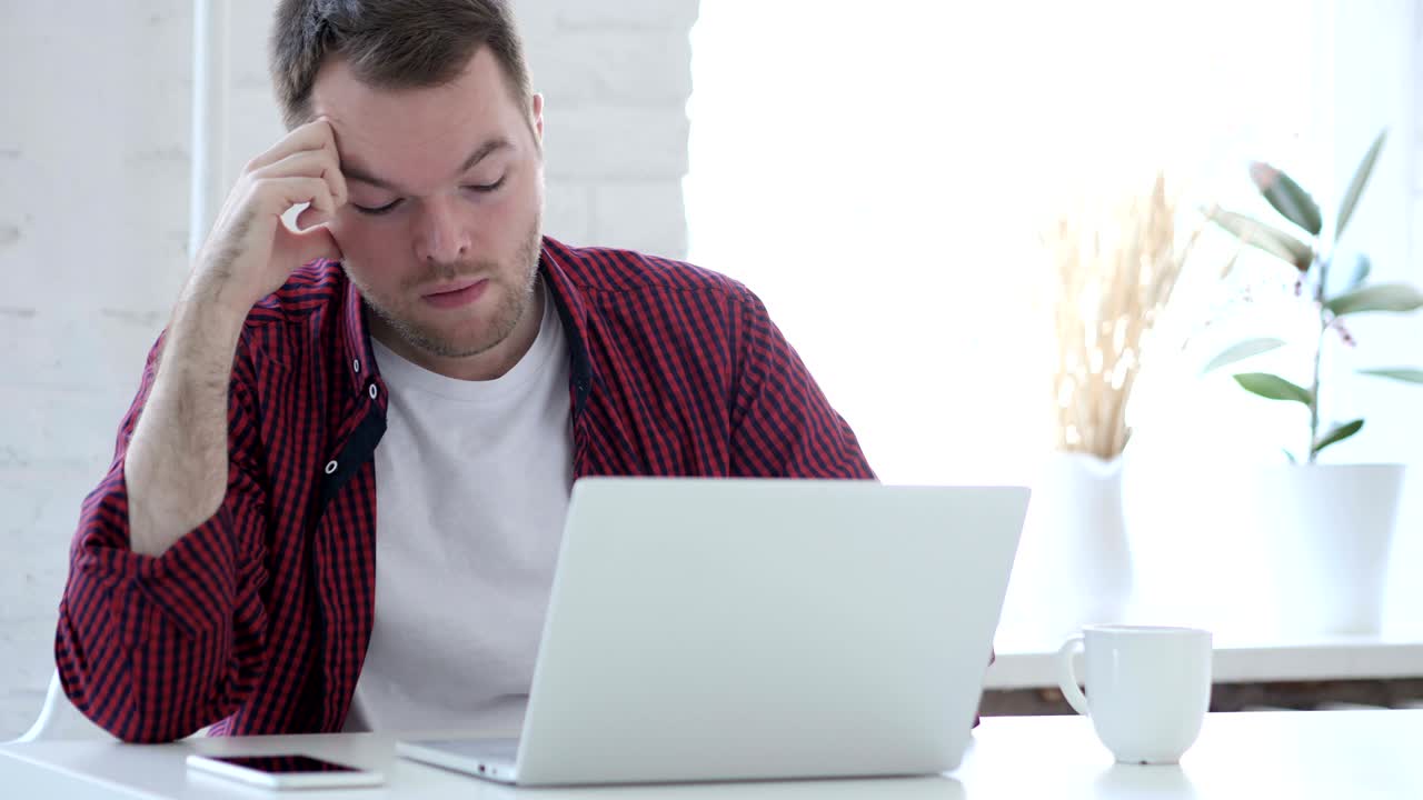 joven cansado bostezando en el trabajo, biblioteca