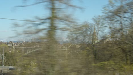 view of bern and the alps in the distance seen from an arriving train