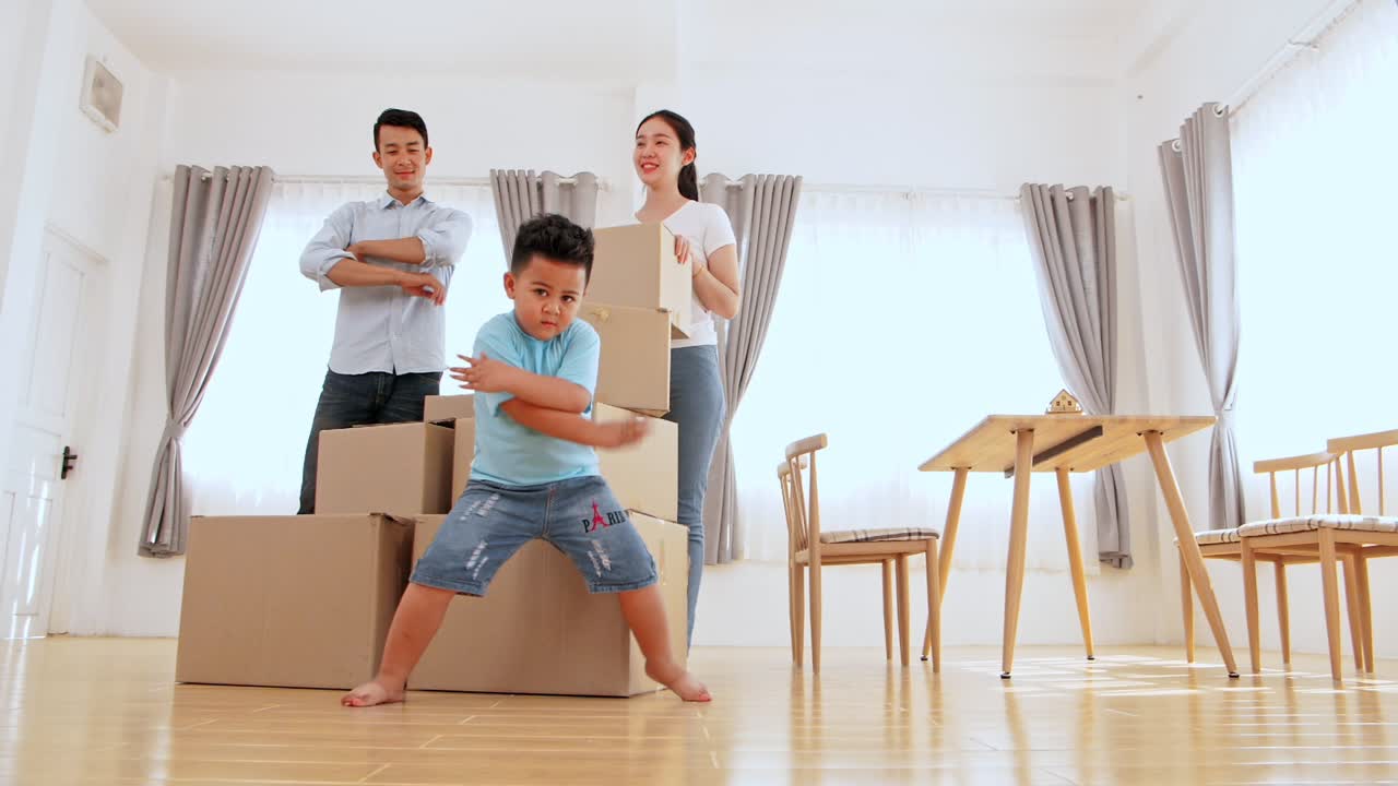 Happy Funny Family And Little Boy Dancing In New House At Moving Day