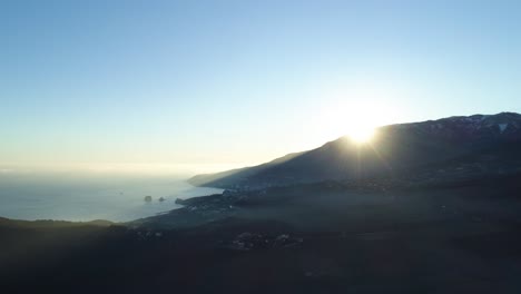 sunrise over mountainous coastline with coastal city