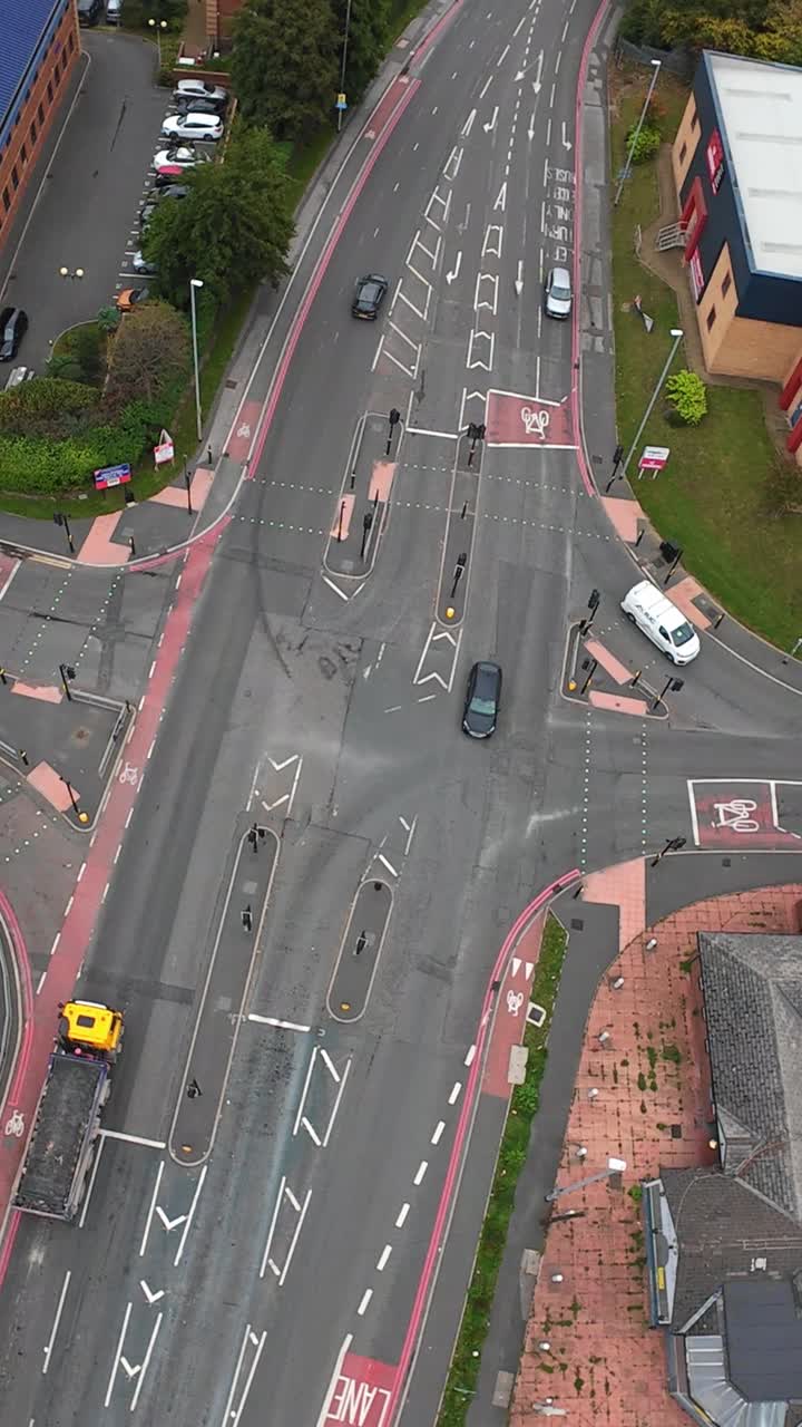 Vertical screen Aerial Road In Leeds Showing Delivery And Freight Vehicles Moving Through Multi Lane Carriageway, Lorries And Vans Negotiate Traffic Islands And Cycle Lanes, Courier Route Scenario,
