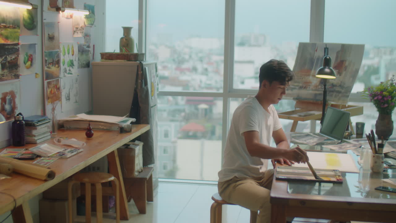 Asian Artist Drawing Picture at Desk in Creative Studio