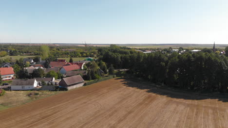 small european farming town village surrounded by agricultural fields, aerial