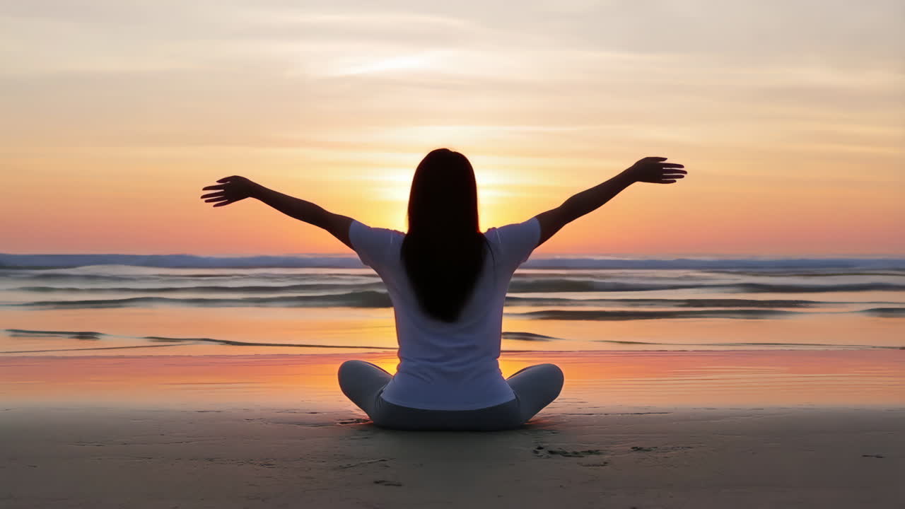 Woman Meditating on Beach at Sunset