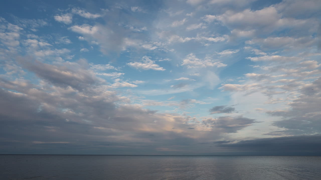 Calm and peaceful view of Lake Ontario with soft clouds and clear blue skies