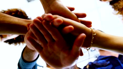 team of smiling graphic designers forming hand stack