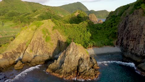 Junger-Kletterer-Steht-Stolz-Auf-Dem-Steilen-Felsen,-Der-Aus-Dem-Meer-Ragt