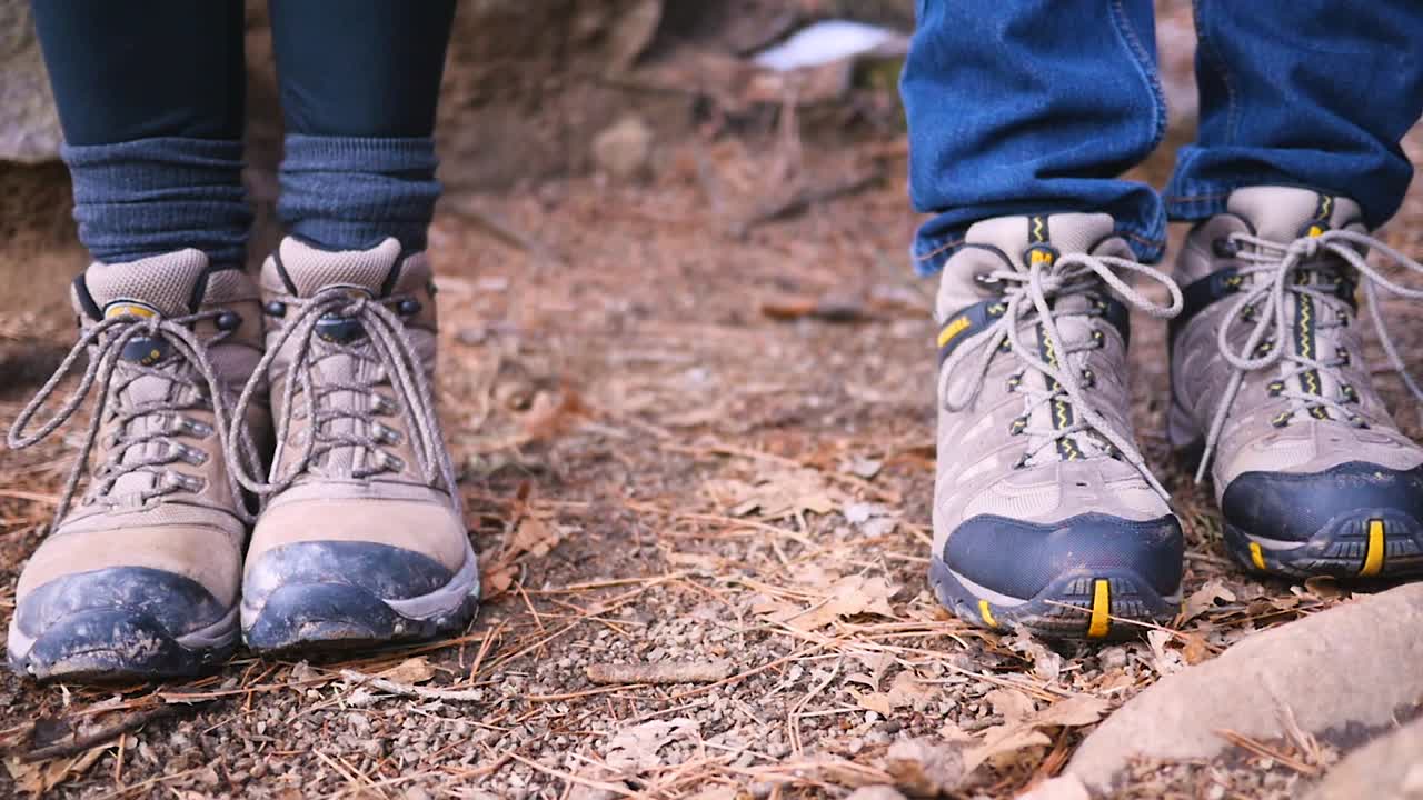 anuncio de revelación de bebé con lindas botas de montaña en el bosque con adorable perro a cámara lenta 4k