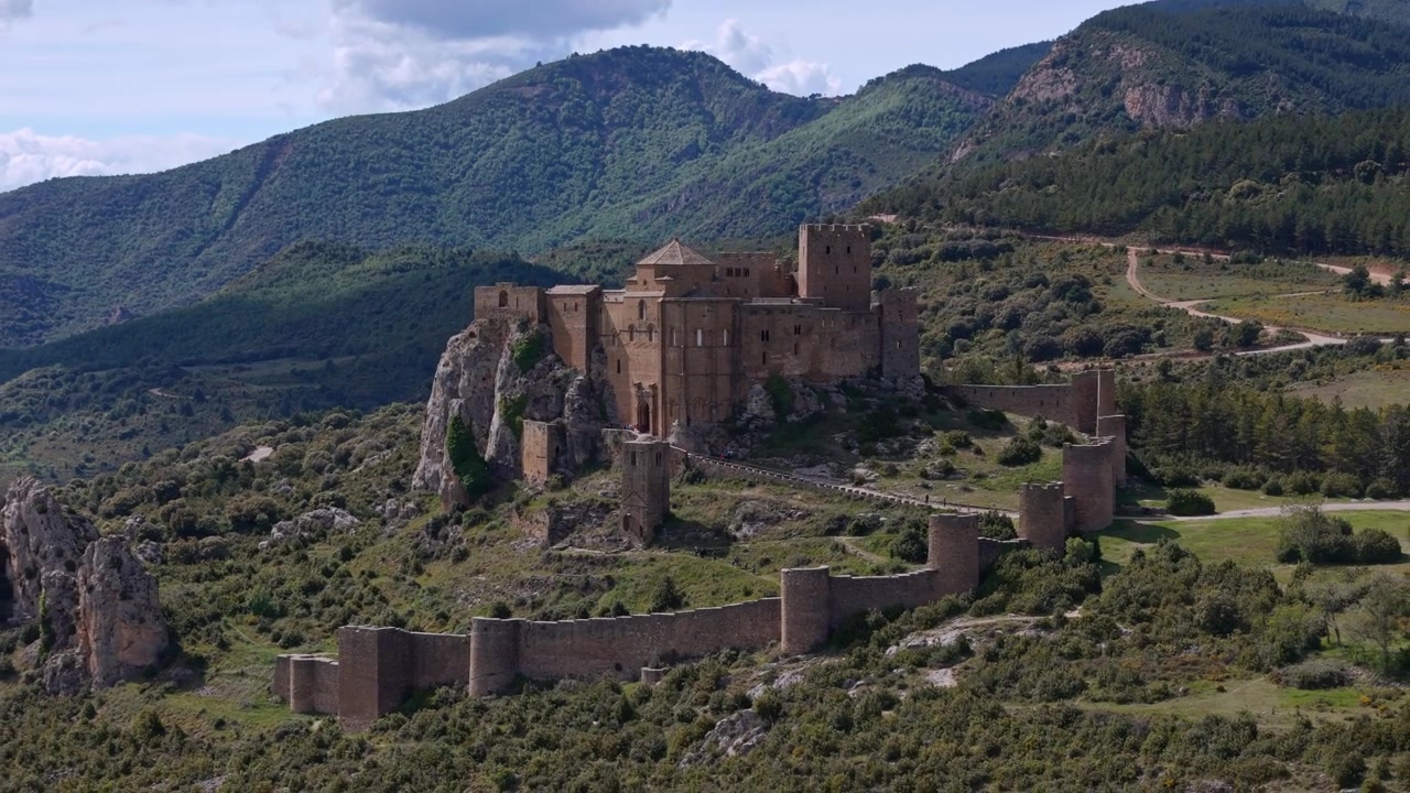 Maestosa vista aerea del castello medievale di Loarre circondato da un lussureggiante paesaggio montano verde