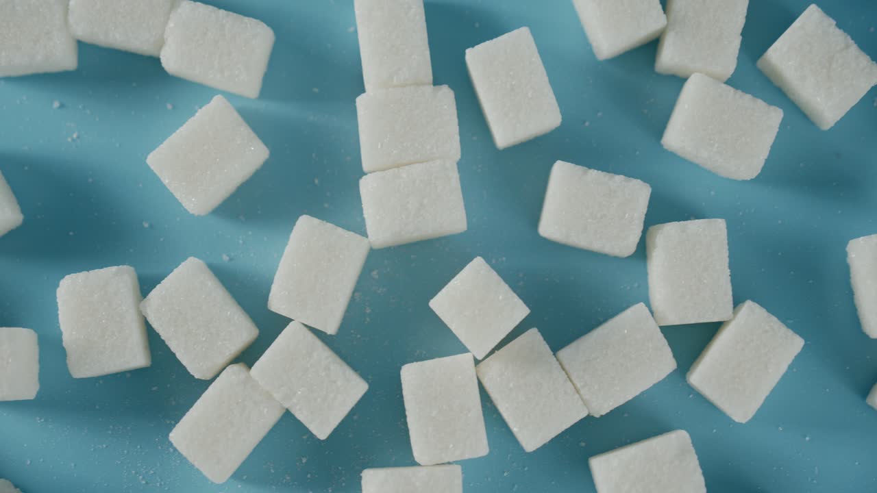 cubos de azúcar en la mesa. sobre un fondo azul.