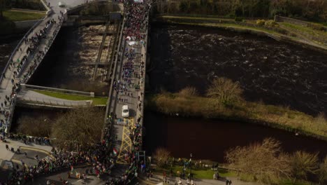 drone descends to showcase parade for saint patrick's day crossing river corrib in galway ireland