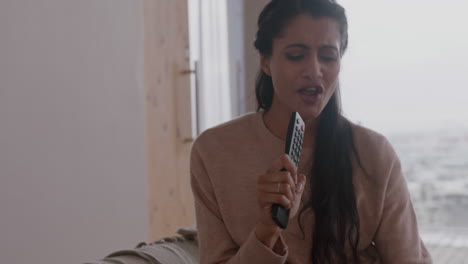 mujer india feliz cantando en casa divirtiéndose celebrando un estilo de vida exitoso bailando disfrutando de la música de karaoke entretenimiento