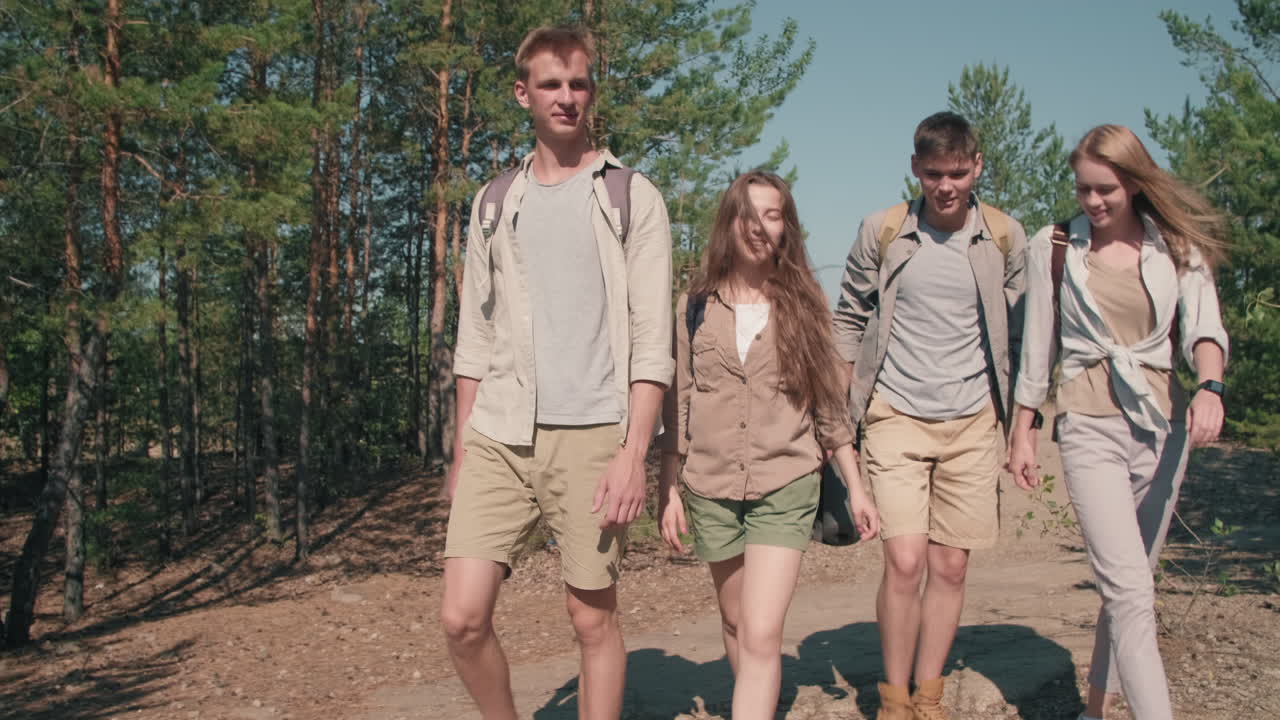 Young Friends Hiking in Forest on Sunny Day
