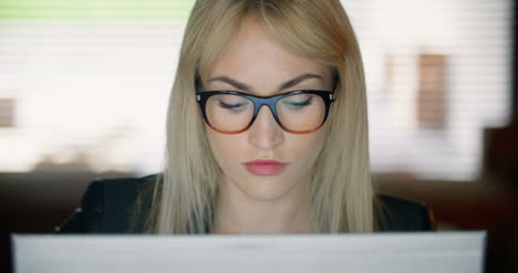 serious young woman using computer late at work