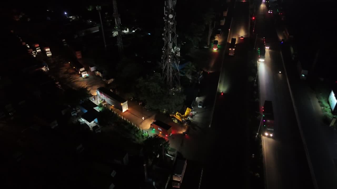 Drone shot looking directly down onto a major expressway with traffic moving at night. Excellent for late-night commerce and transportation themes