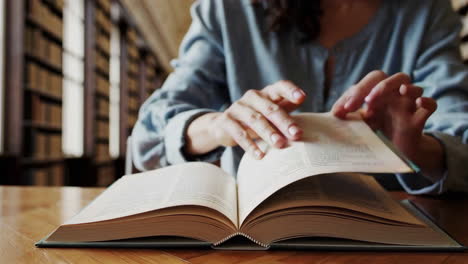 mujer leyendo un libro en una biblioteca