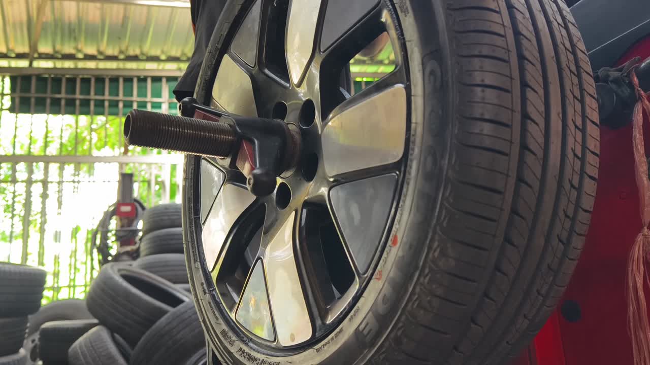 Car Wheel Spinning on Balancing Machine in Auto Repair Shop