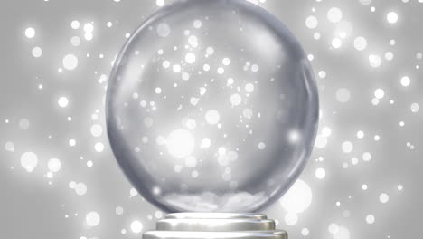 animation of snow globe over snow falling on grey background