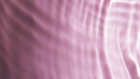 Video-of-close-up-of-waves-of-water-with-copy-space-on-pink-background