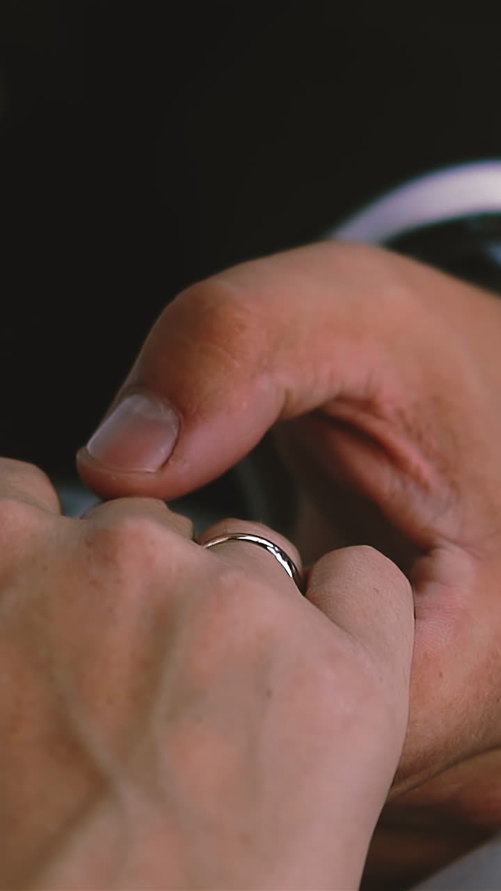 CU, slow motion: careful young groom with wrist watch strokes fingers of future wife with engagement ring and in gorgeous white dress extreme close view