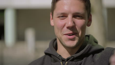 cheerful young man talking and looking at camera