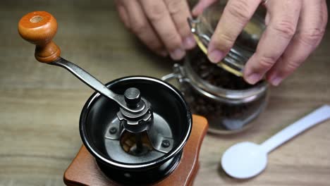 coffee grinder, jar with roasted coffee beans, spoon