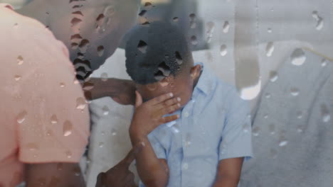 animación de gotas de lluvia sobre padre afroamericano gritando a su hijo llorando