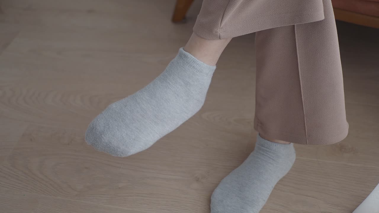 Close-up de um par de meias curtas cinzas nos pés de uma mulher