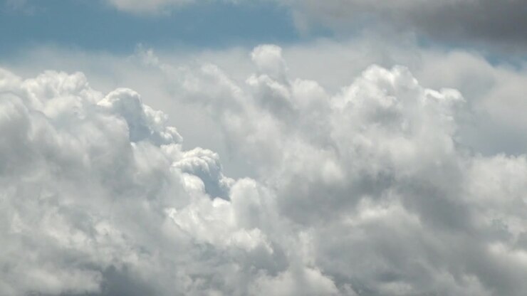 A time lapse large clouds building in a blue sky.
