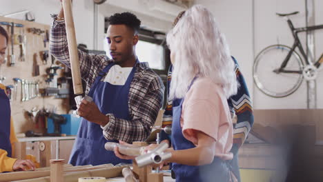 Equipo-Multicultural-De-Aprendices-En-Un-Taller-Ensamblando-Cuadros-De-Bicicletas-Construidos-A-Mano.