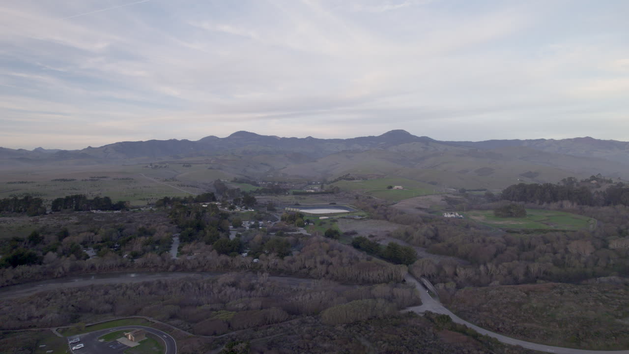 Rolling Hills and Quiet Farmland Stretch Beneath Soft Skies in Cambria and San Simeon, California - Drone Flying Forward