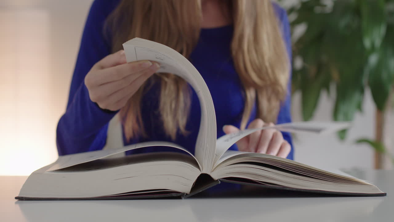 Una donna sfoglia le pagine di un libro.