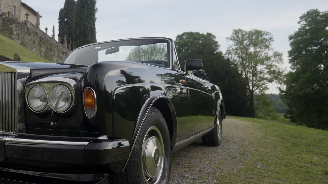 Luxury Black Convertible Rolls Royce in a Scenic Countryside Setting