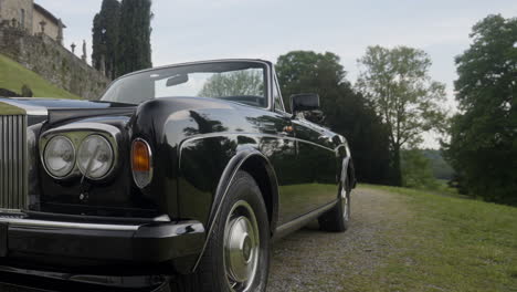 luxury black convertible rolls royce in a scenic countryside setting