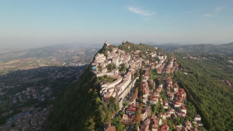 San-Marino,-Italy,-city-on-a-mountain,-city-building,-drone-pull-out-view