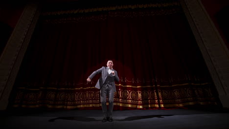 portrait of a comedian talking. cheerful actor in suit telling funny stories and gesticulating a lot. joyful man performing on stage.