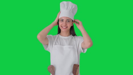 feliz india mujer chef profesional preparándose para cocinar pantalla verde