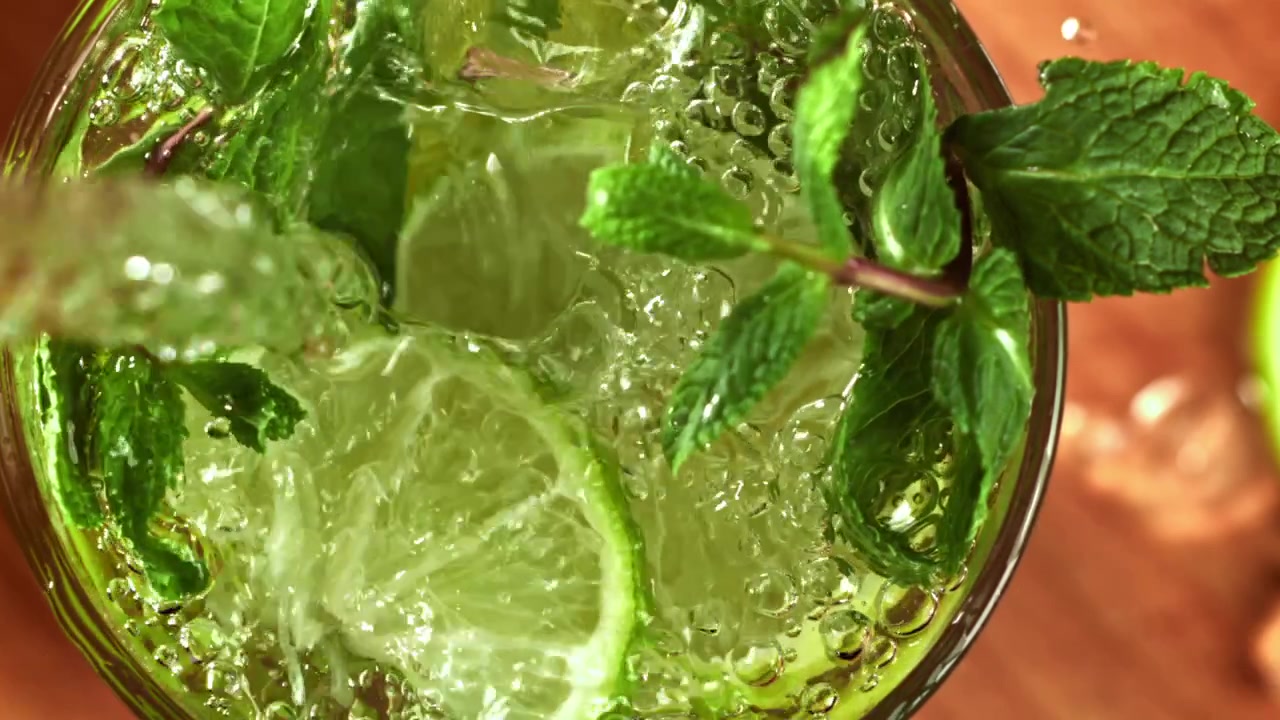 Hidastettu kaato virkistävästä Mojito-cocktailista limellä ja mintulla