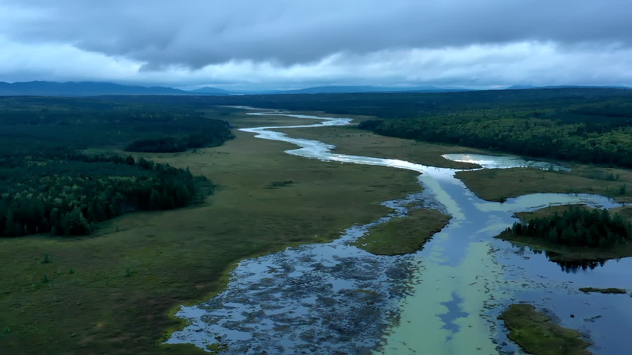 Aerial hyperlapse flying over a dark ominous landscape with the still waters of Shirley Bog winding through the forested Maine countryside and reflections of the stormy sky above