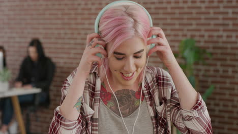 retrato hermosa joven mujer punk estudiante se pone auriculares disfrutando de un estilo de vida relajado escuchando música usando estilo de moda alternativo cabello rosa